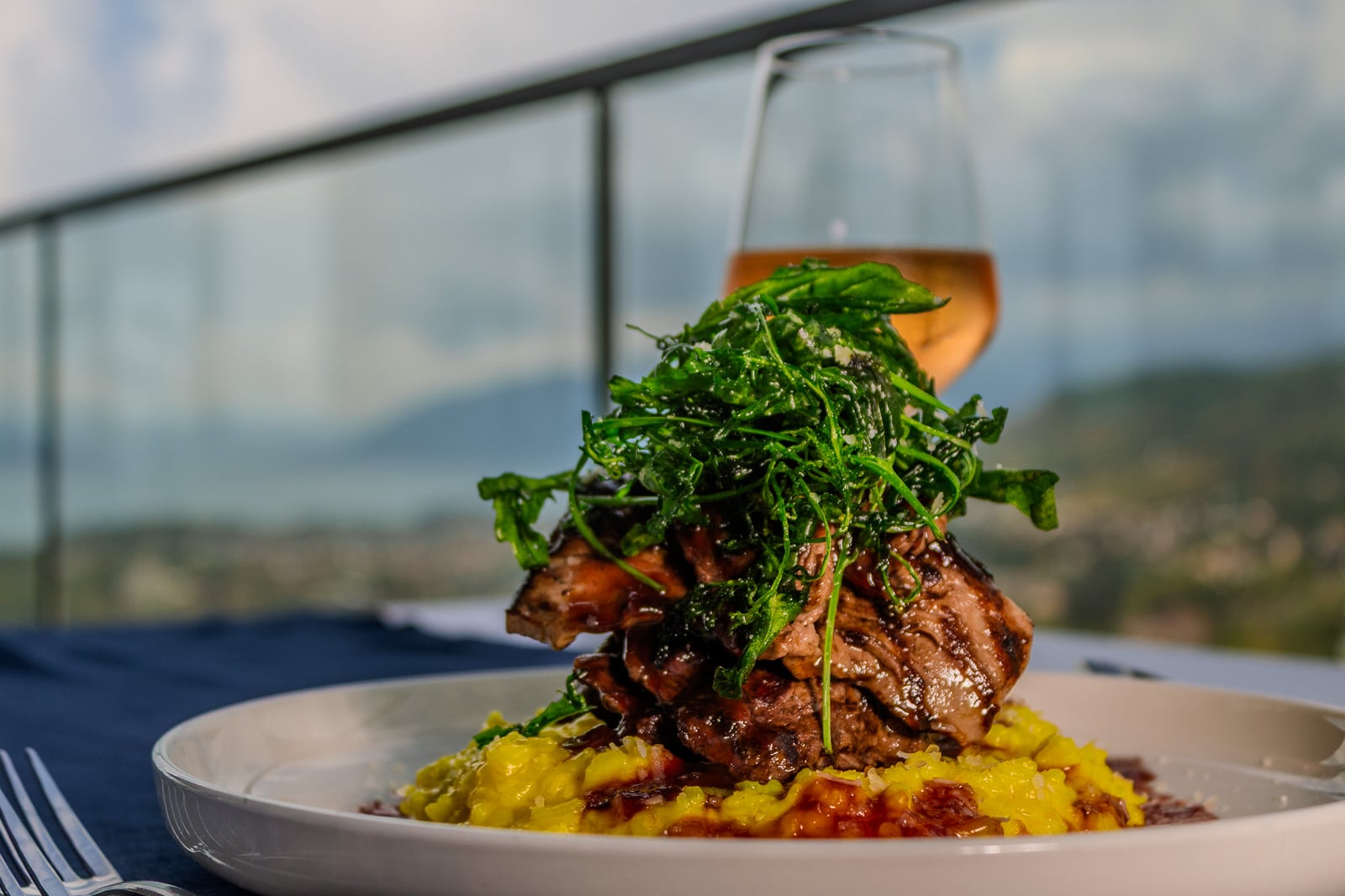 A plated main course with risotto and greens at Cielo